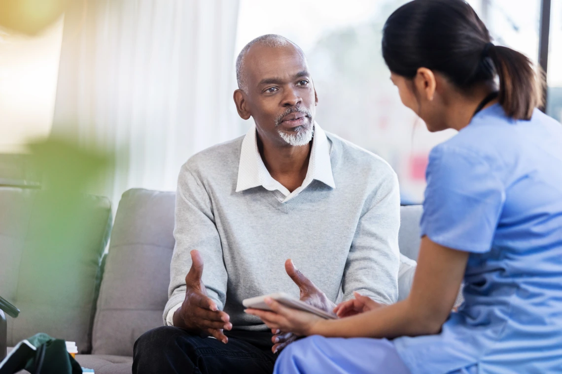 A doctor talking with man answering his questions.